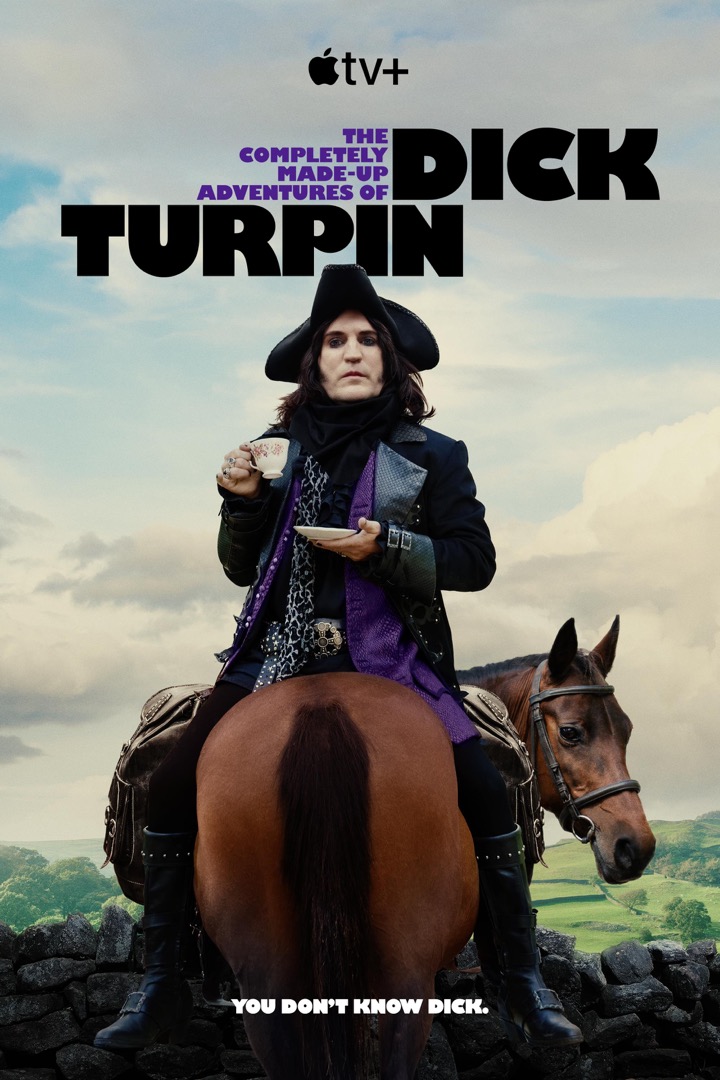 Noel Fielding, dressed as a dandy highwayman, sitting backwards on a horse