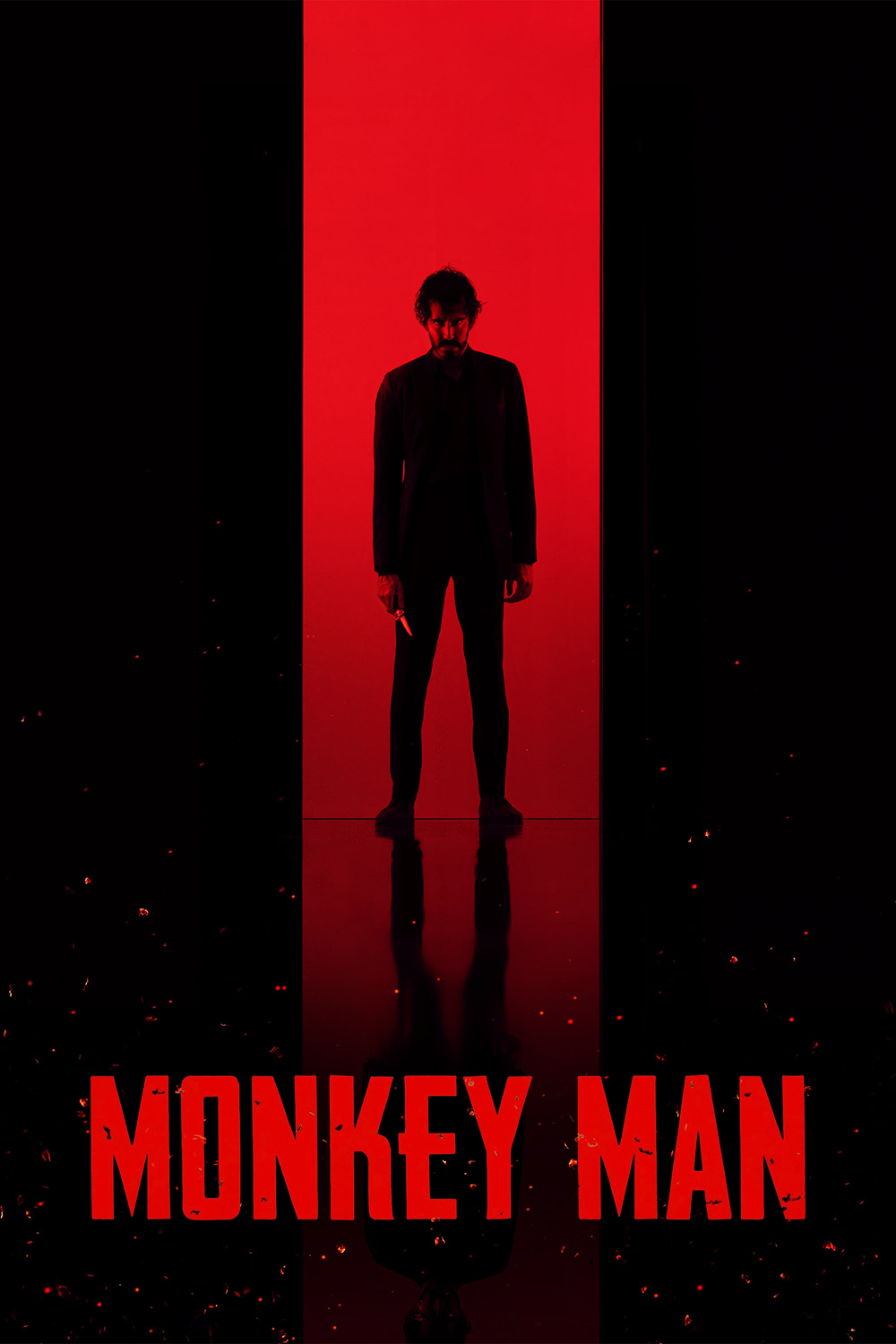 a black silhouette of Dev Patel standing menacingly in red doorway, holding a knife