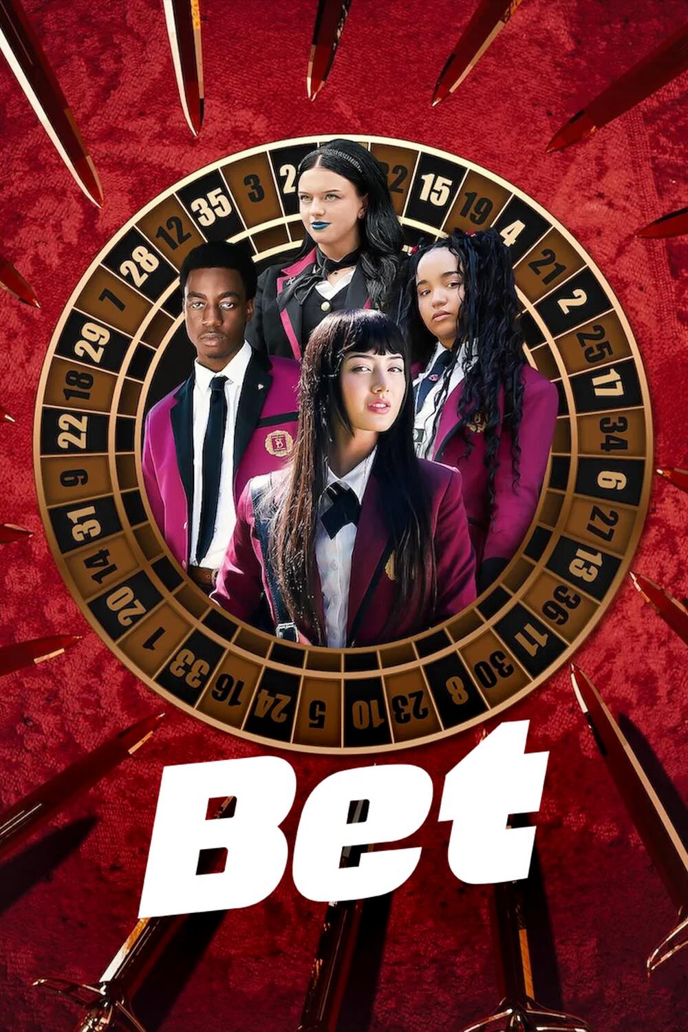 4 teenagers, 1 boy and 3 girls, wearing school blazers pictured inside a roulette wheel. The wheel is surrounded by a red velour background, onto which a large variety of knives have been laid, pointing inwards.