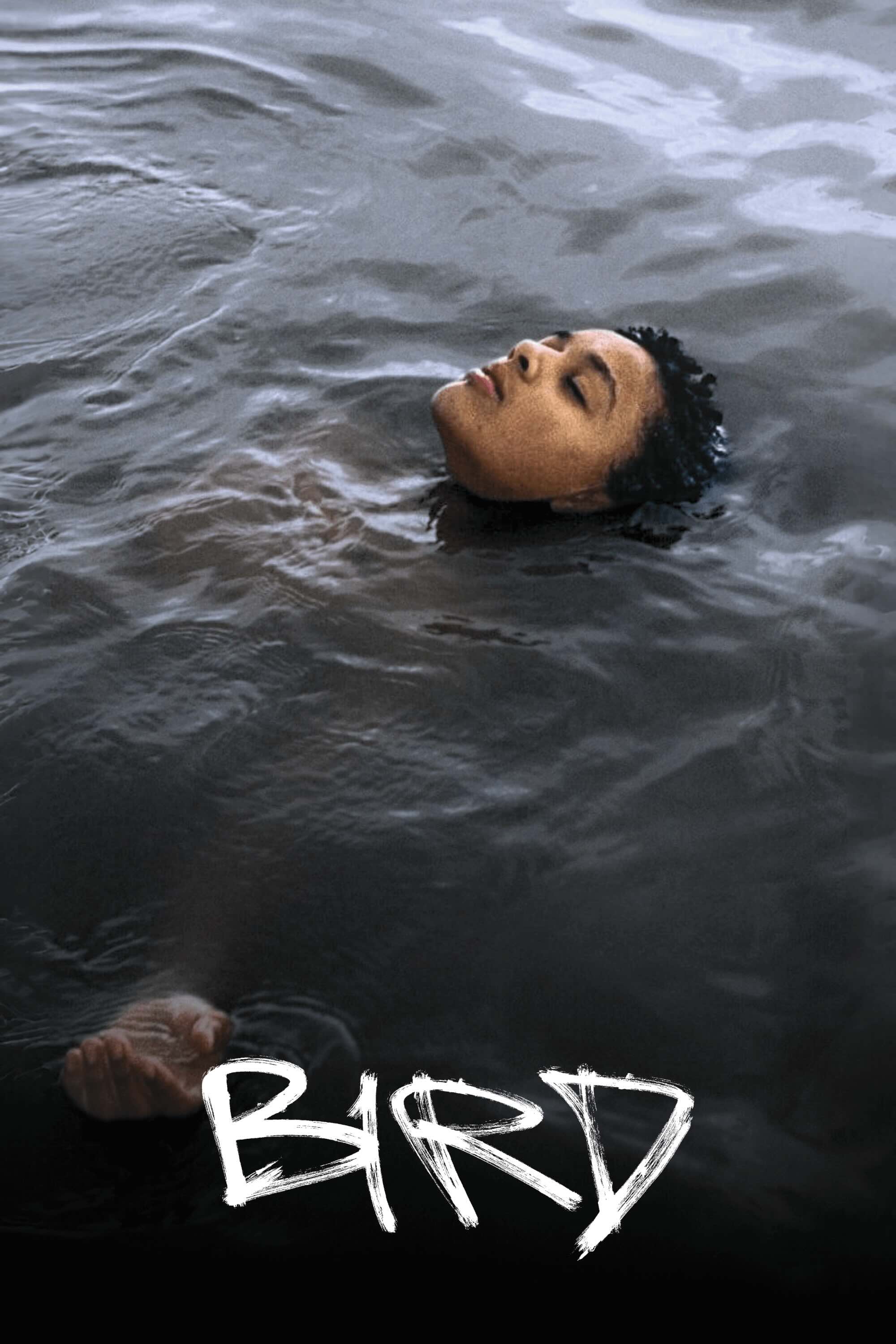 A young, short haired black girl floats on her back in dark water