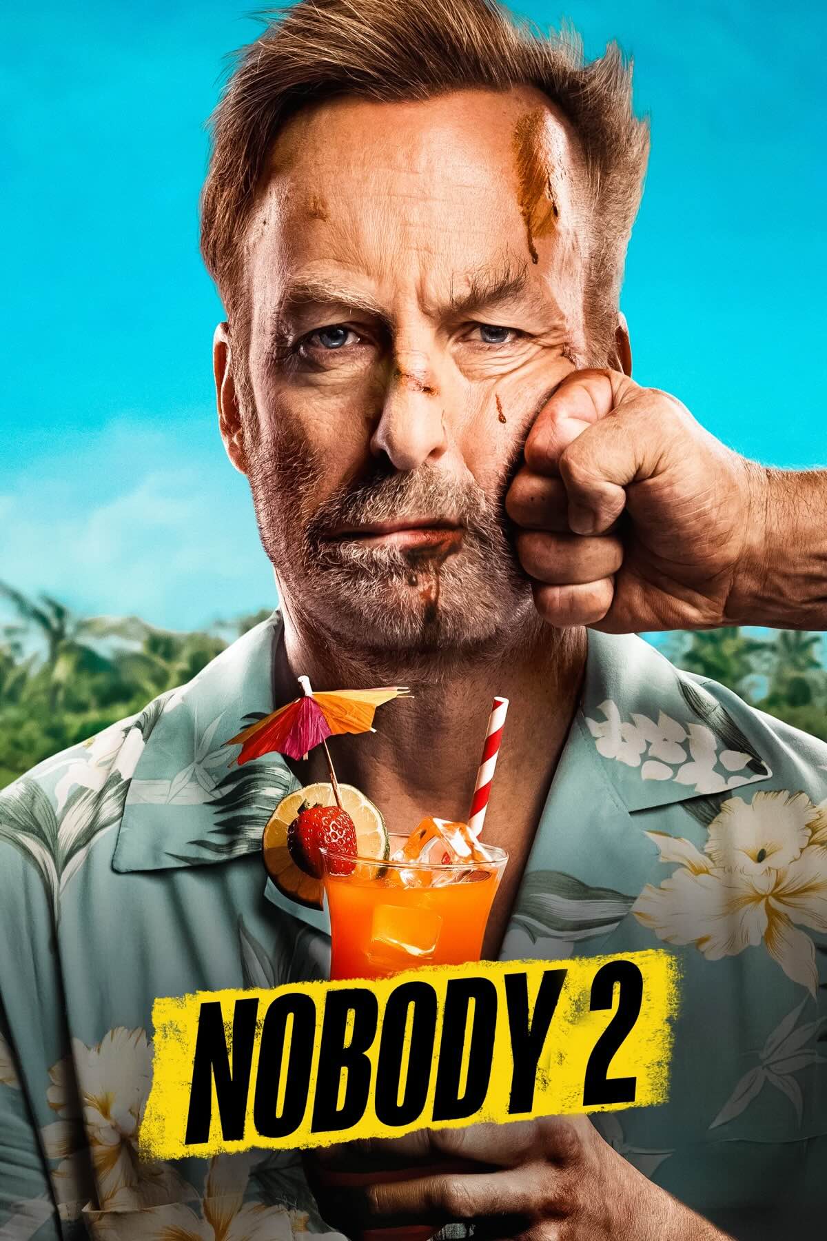 A middle aged, bored looking man, wearing a Hawaiian shirt and holding a cocktail being punched in the side of the face