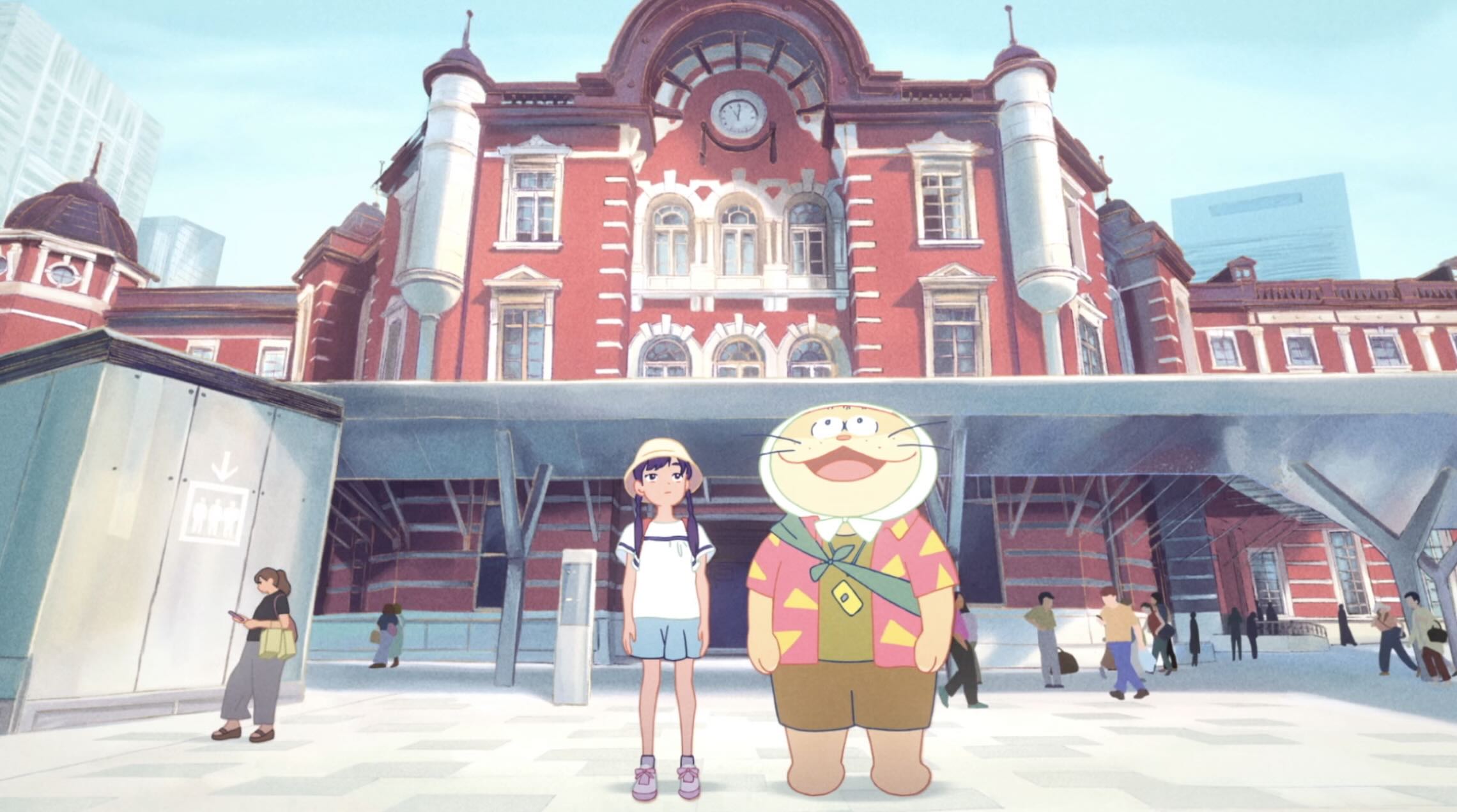 A young girl and a large cartoon cat, wearing a head scarf to keep cool, stand outside a railway station. The cat look in awe at the world.