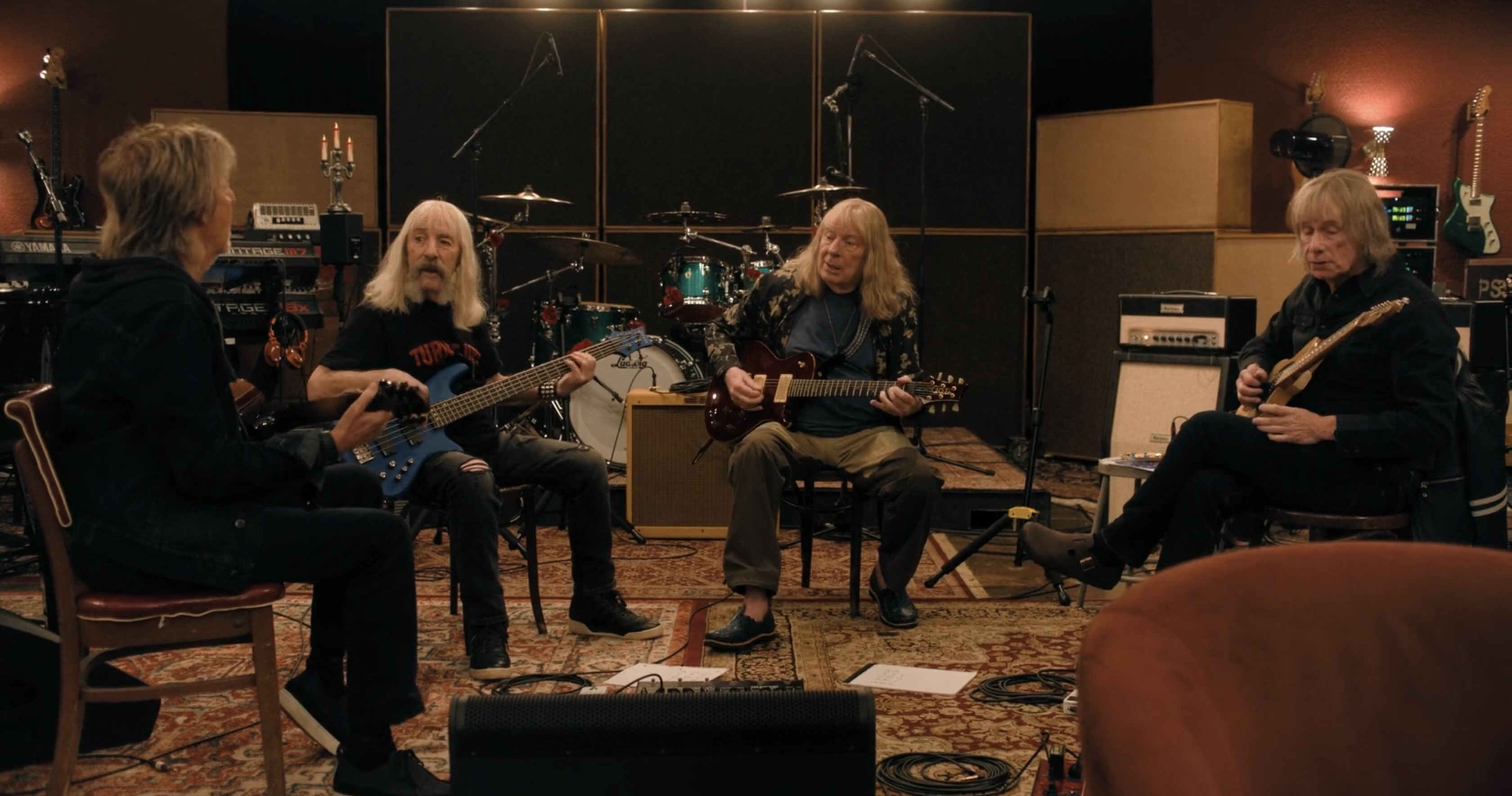 The same three aging rockers, sat playing guitars in a rehearsal studio. Paul McCartney has joined them to play.