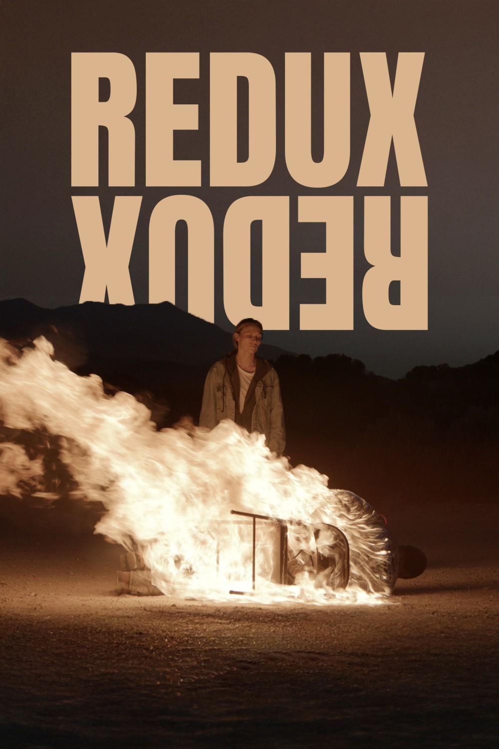 Poster for the film Redux, Redux. A nighttime scene. A man is tied to a chair, lying on the ground, completely aflame. A slim, blonde woman is standing over him looking down at him coldly.