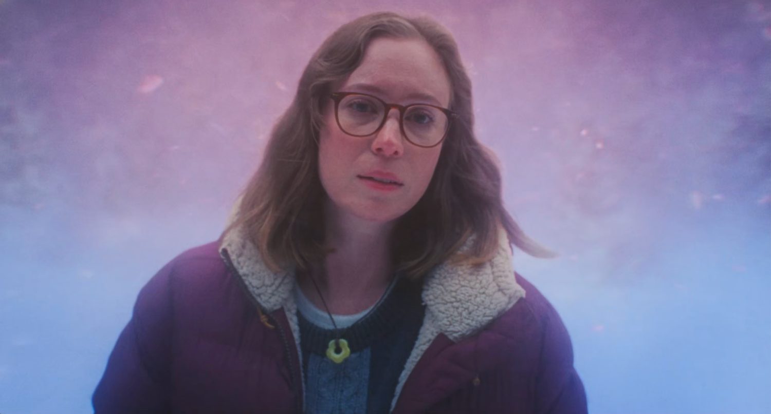 The same brunette from the poster, this time wearing glasses, a big winter coat and no blood. She's looking adoringly at something off camera. The background is an expressionistic snow scene with a pink tinge.