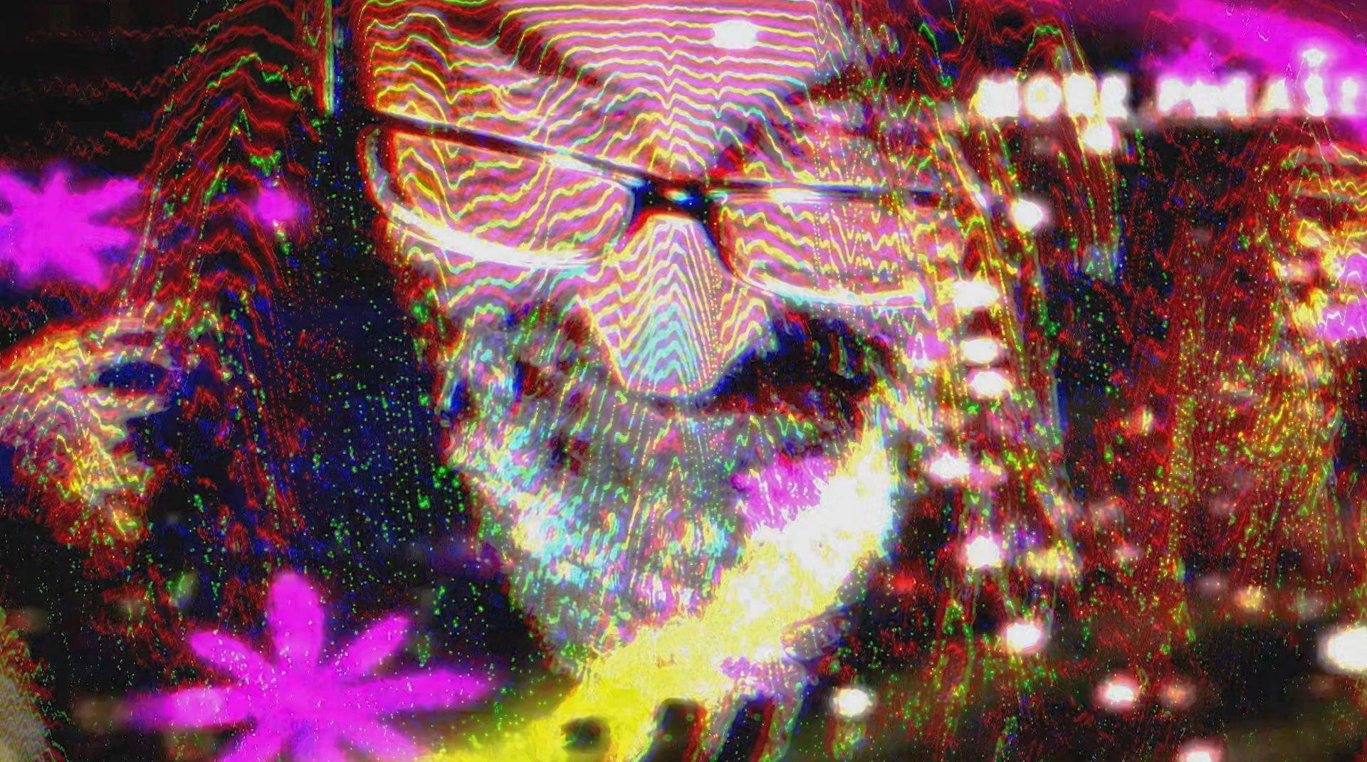 The same man with long brown hair, with a psychedelic lights projected onto his face.