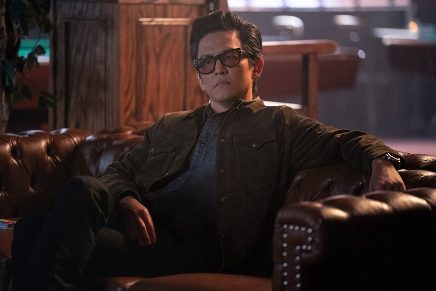 John Cho sitting in a leather chair
